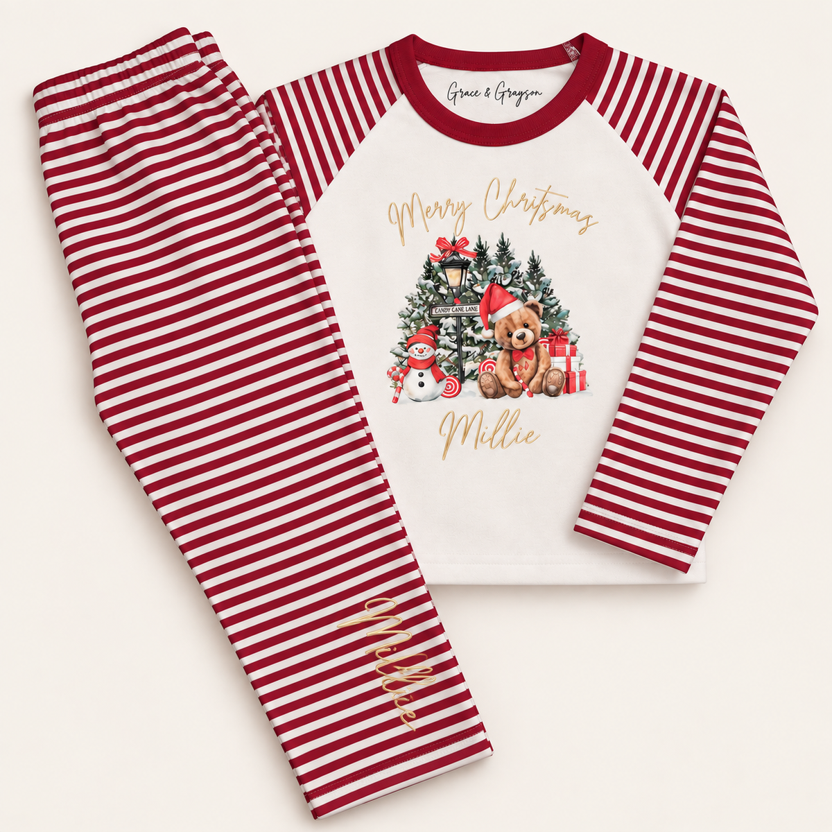 Children’s personalised red stripe Candy Cane Lane Christmas pyjamas featuring a festive bear and candy cane artwork by Grace & Grayson