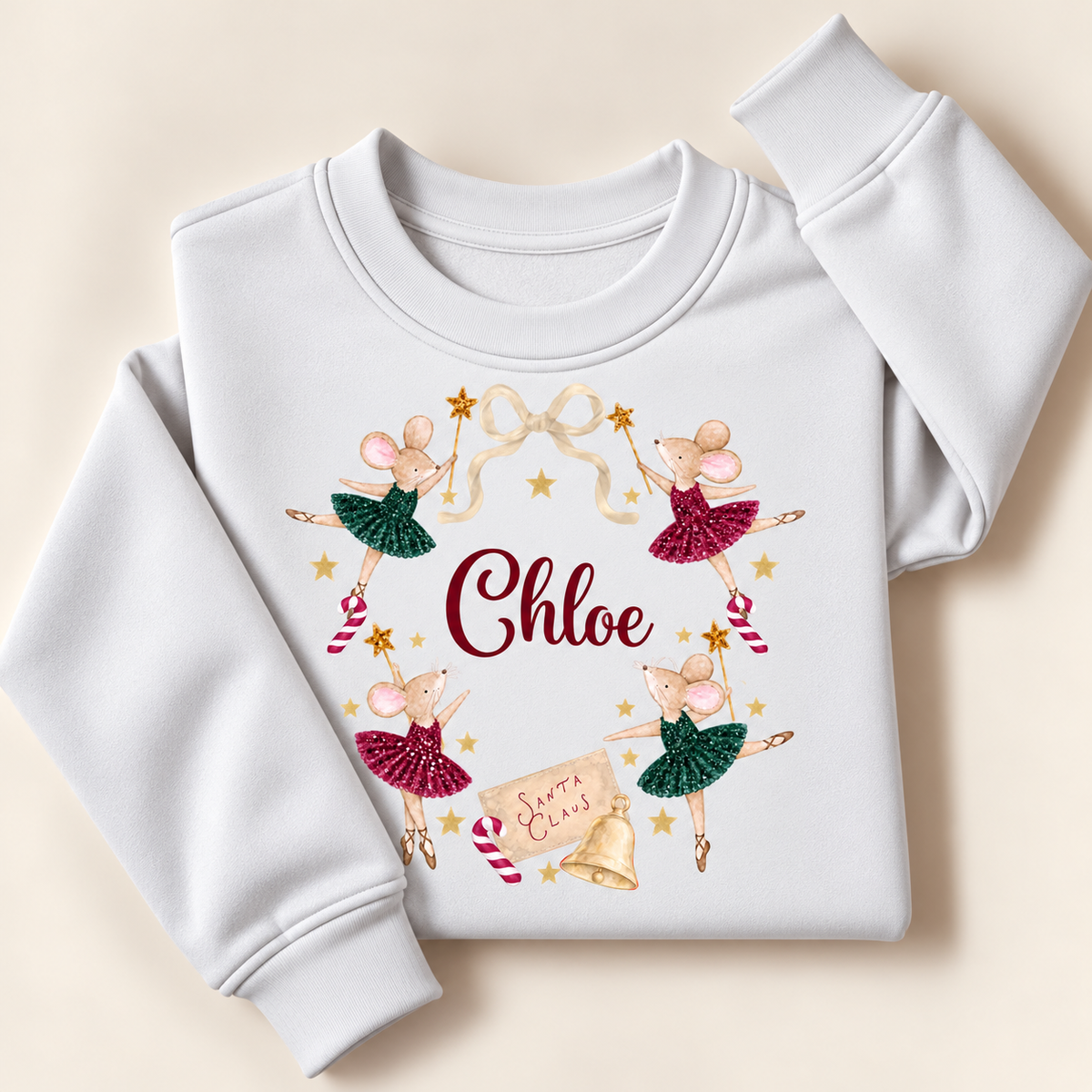 Personalised white Christmas sweatshirt with ballerina mice in red and green tutus, festive bow, stars and bell, laid flat | Grace & Grayson