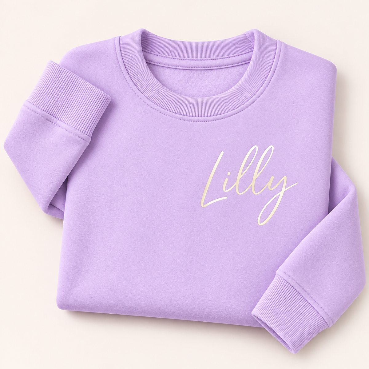 Lilac personalised sweatshirt with a small cream script name on the chest, folded on a beige background | Grace & Grayson