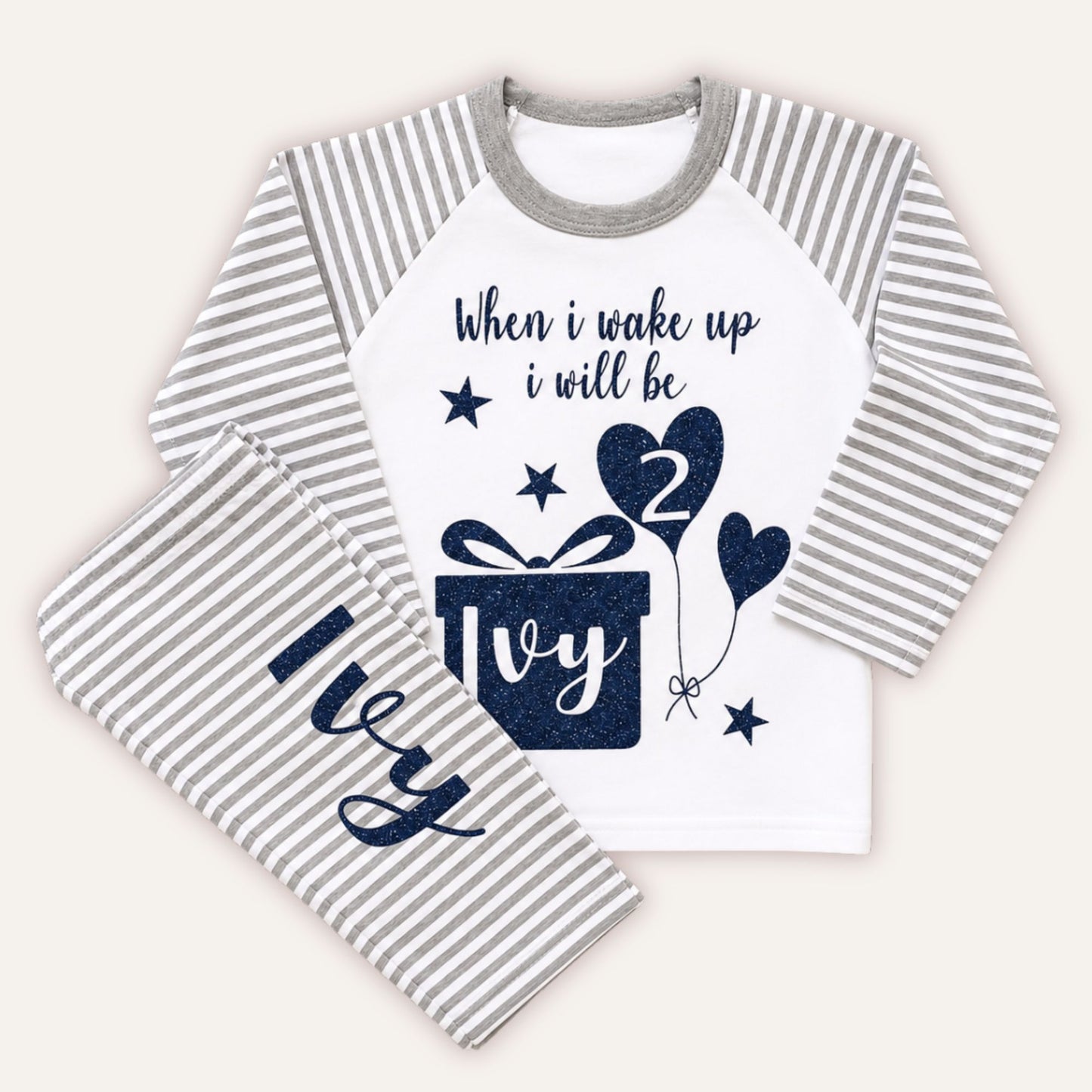 Personalised girls 1st birthday grey striped pyjamas with glitter birthday design, gift box graphic, number 1 balloon and personalised name on matching bottoms.