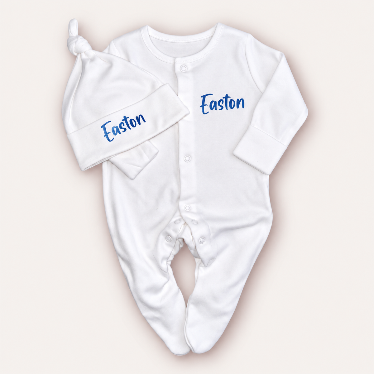 White personalised baby grow and matching knotted hat with blue lettering, Grace & Grayson