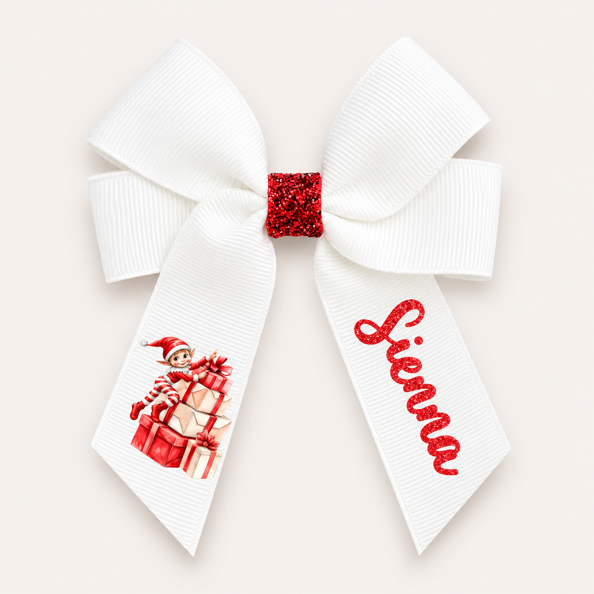 White hair bow with a red glitter centre, an elf sitting on presents and red glitter personalised lettering, Grace & Grayson.