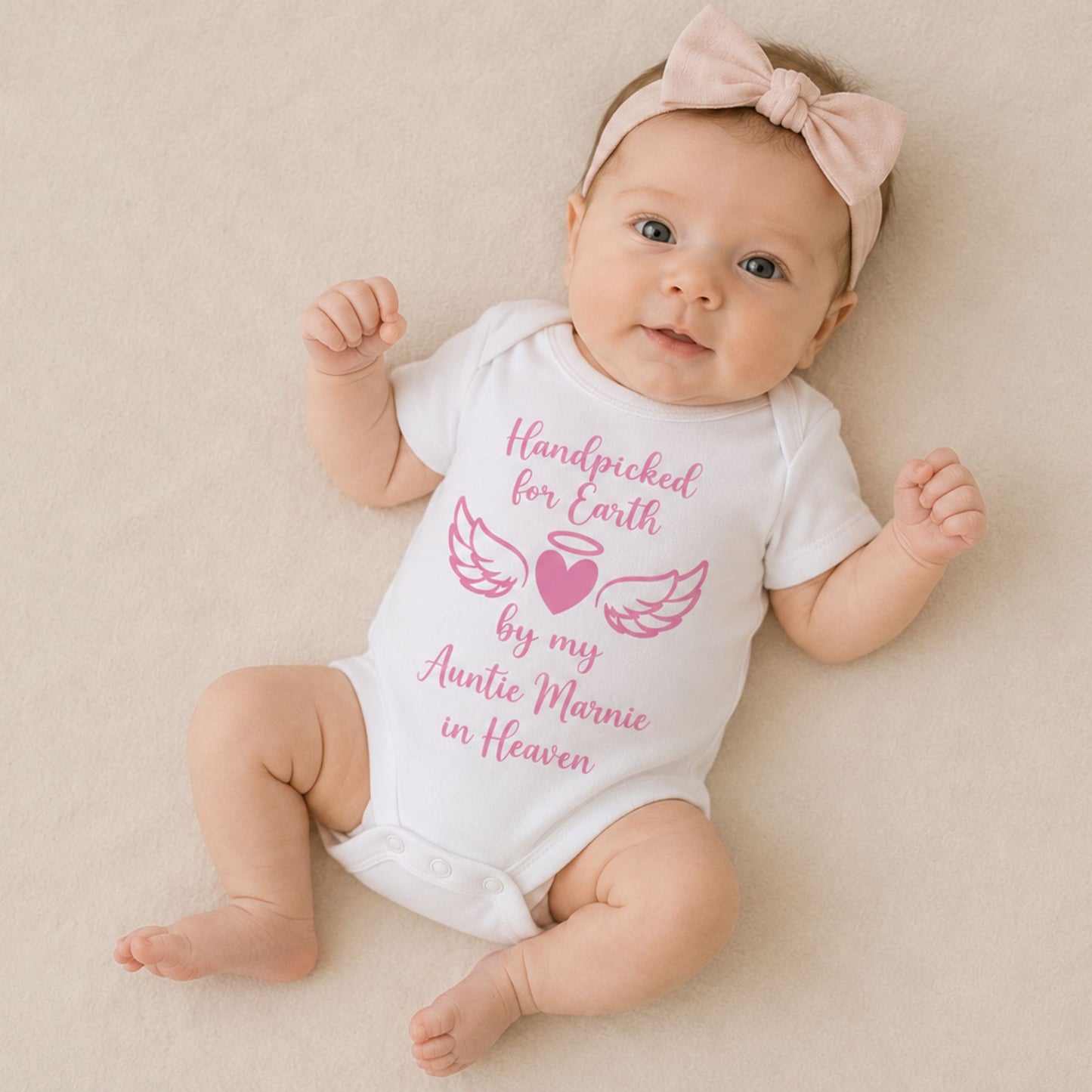 Baby girl wearing personalised Handpicked for Earth baby vest with pink angel wings and heart design - Grace & Grayson