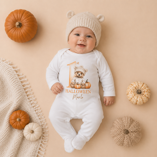 Baby wearing personalised 1st Halloween pumpkin bear baby grow with bear beanie hat, surrounded by pumpkins Grace & Grayson