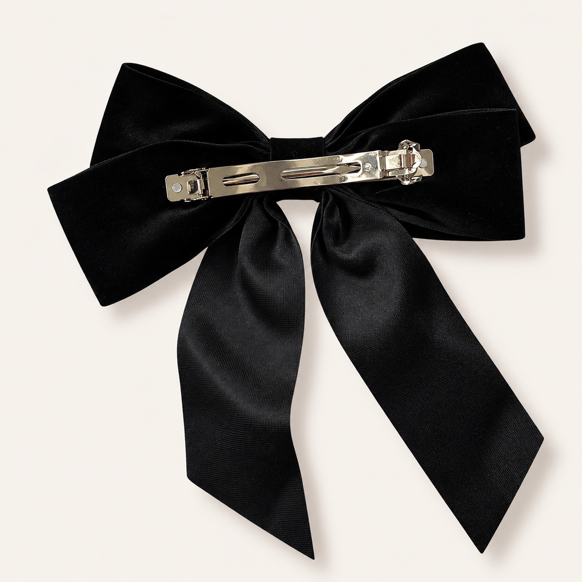 Back view of a large black velvet hair bow showing its silver-tone metal barrette clip, Grace & Grayson.