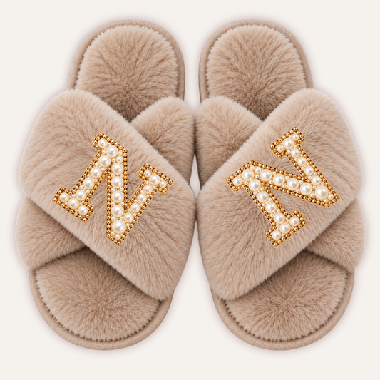 Beige faux fur crossover slippers with pearl initials and gold-tone edging, Grace & Grayson.