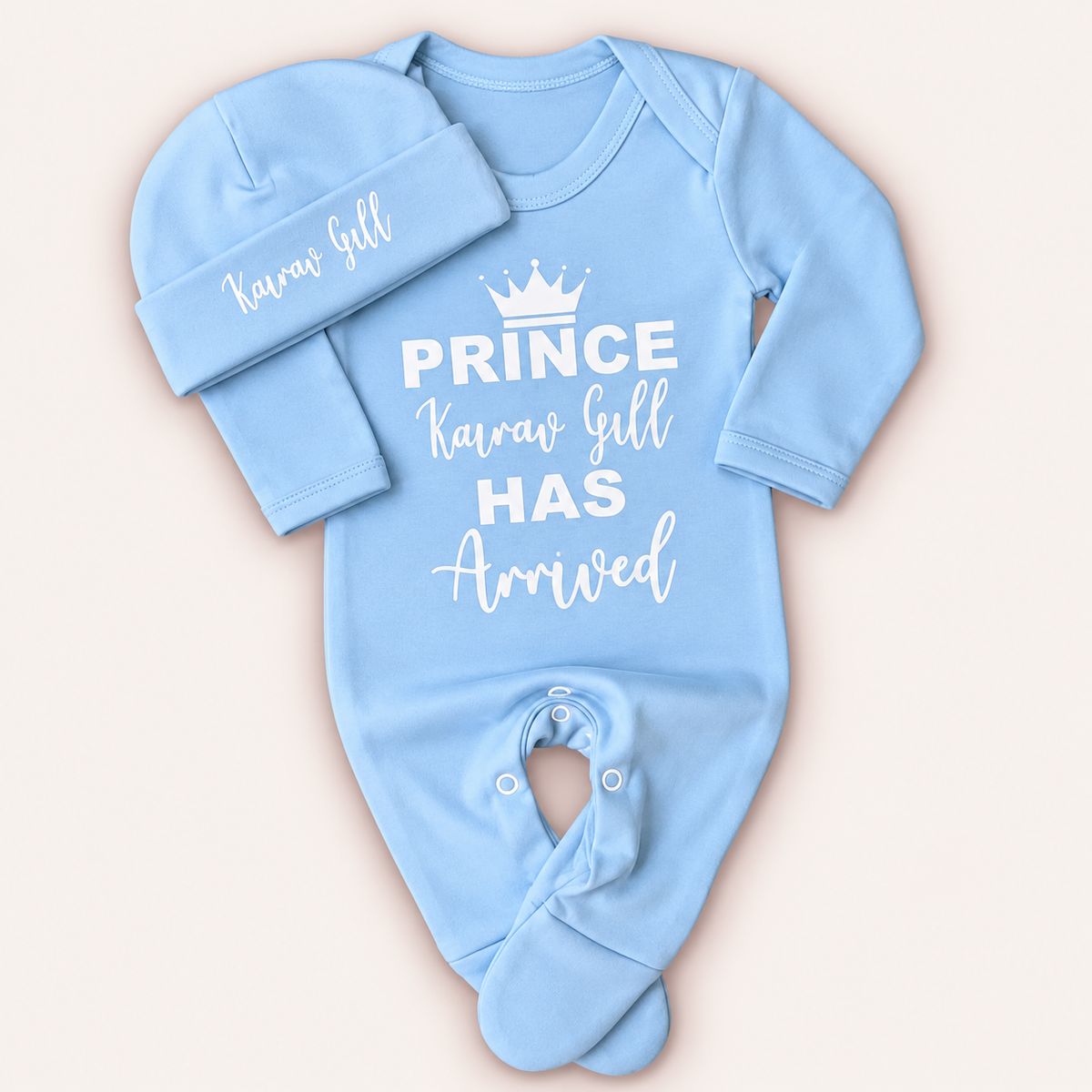 Blue personalised Prince Has Arrived baby grow and matching hat with white crown lettering, Grace & Grayson