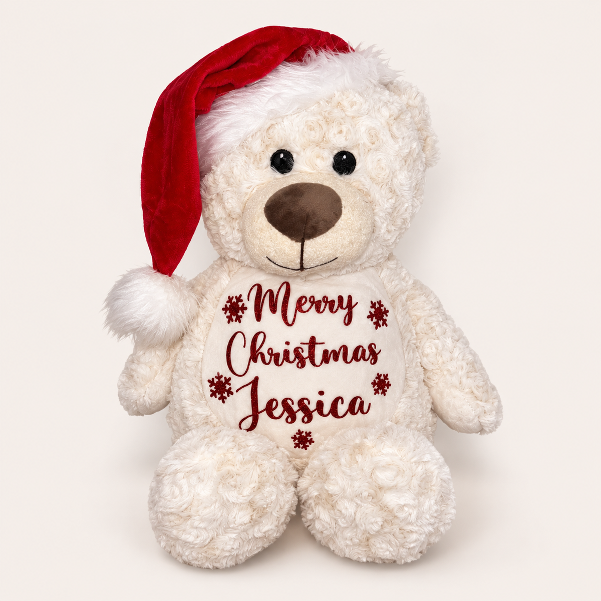 Cream personalised Christmas teddy bear wearing a Santa hat with a Merry Christmas design, displayed on a light background, Grace & Grayson