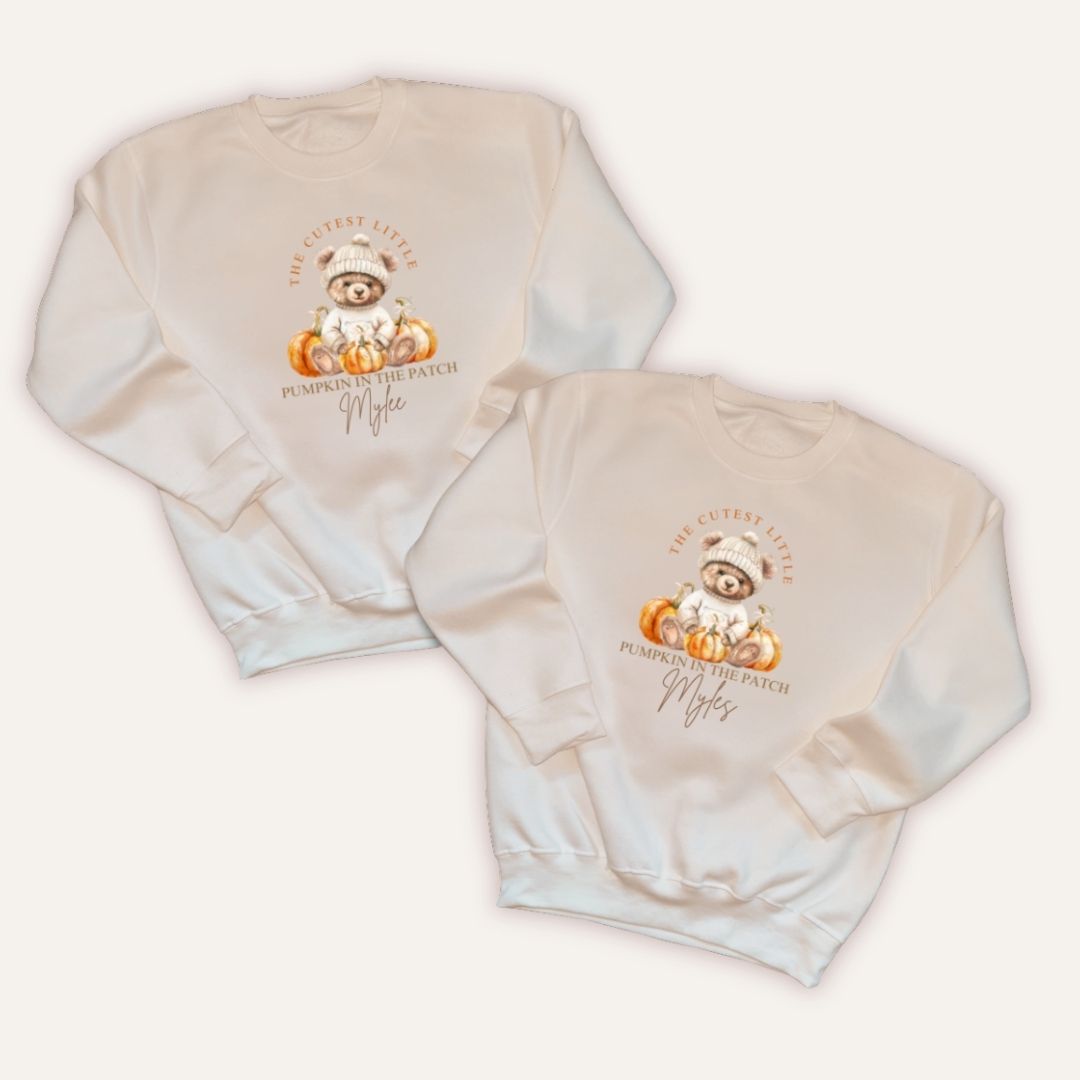 Flat lay of two Grace & Grayson personalised pumpkin in the patch kids sweatshirts in natural with custom name print