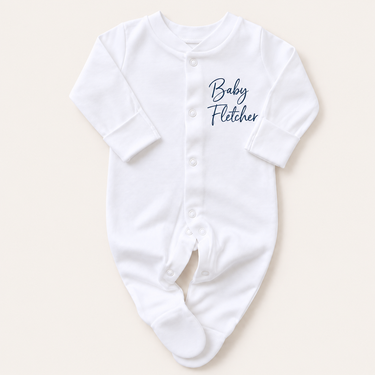 Front view of a white personalised baby grow with custom name lettering on the chest and popper fastening, Grace & Grayson