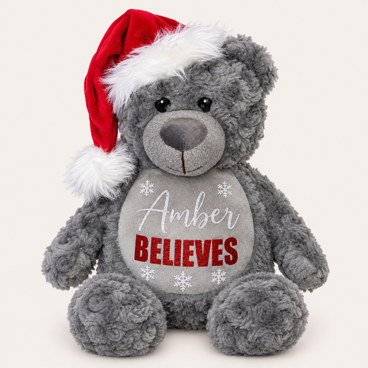Grey personalised Believes Christmas teddy wearing a Santa hat with red snowflake details, Grace & Grayson