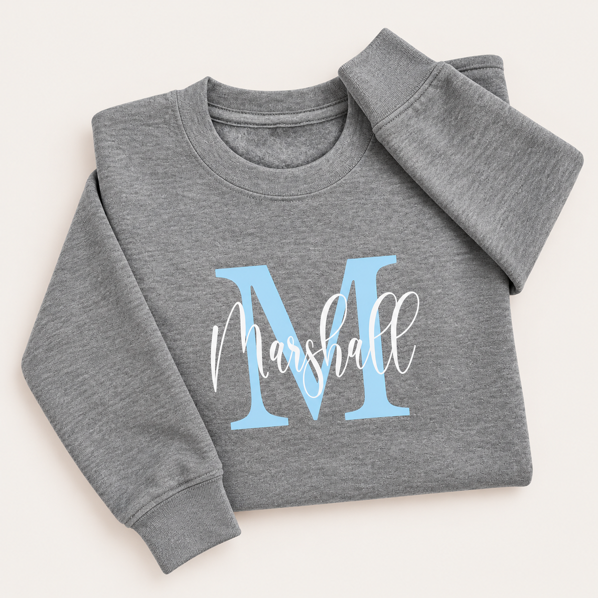 Grey personalised sweatshirt with a light blue initial and white script name, laid flat | Grace & Grayson