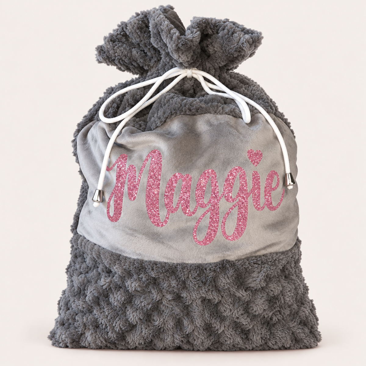Grey plush personalised Christmas Santa sack with pink glitter name lettering and white drawstrings against a light background, Grace & Grayson.