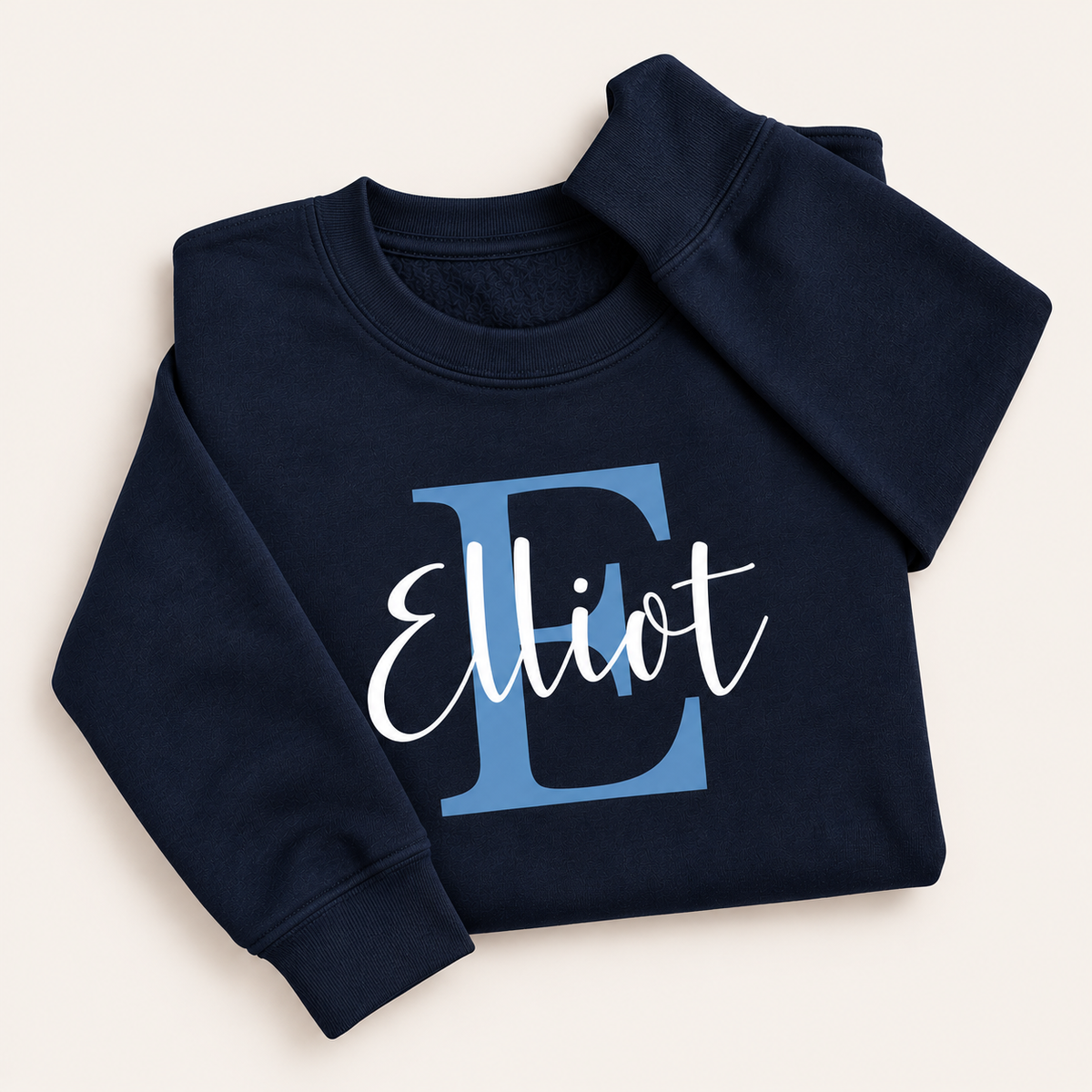 Navy personalised sweatshirt with a blue initial and white script name, laid flat | Grace & Grayson