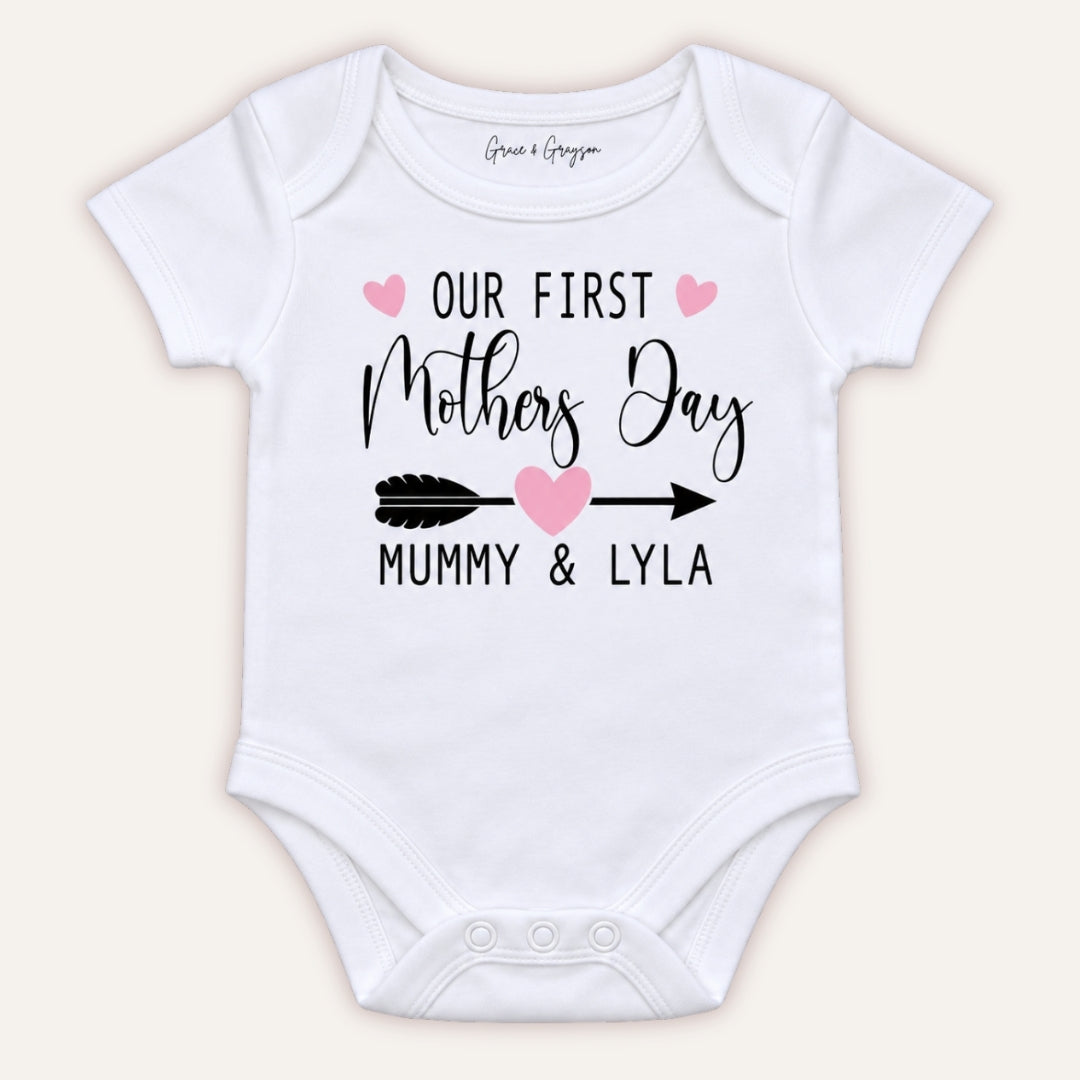 White personalised Our First Mother’s Day baby vest with pink hearts and arrow design, Grace & Grayson