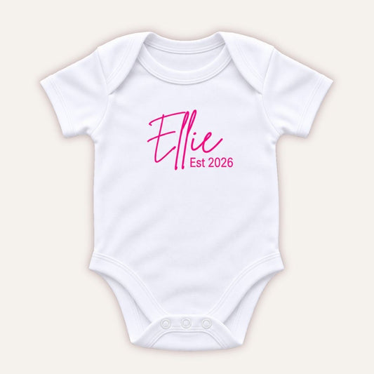 Personalised EST baby vest in pink featuring a baby’s name and year of birth, Grace & Grayson.
