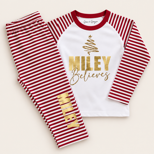 Personalised red and white striped Christmas pyjamas with gold Christmas tree, bold name and “Believes” design by Grace & Grayson