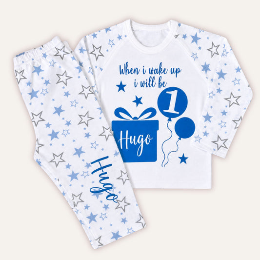Personalised boys blue star print birthday pyjamas with custom name gift box and age balloon birthday design.
