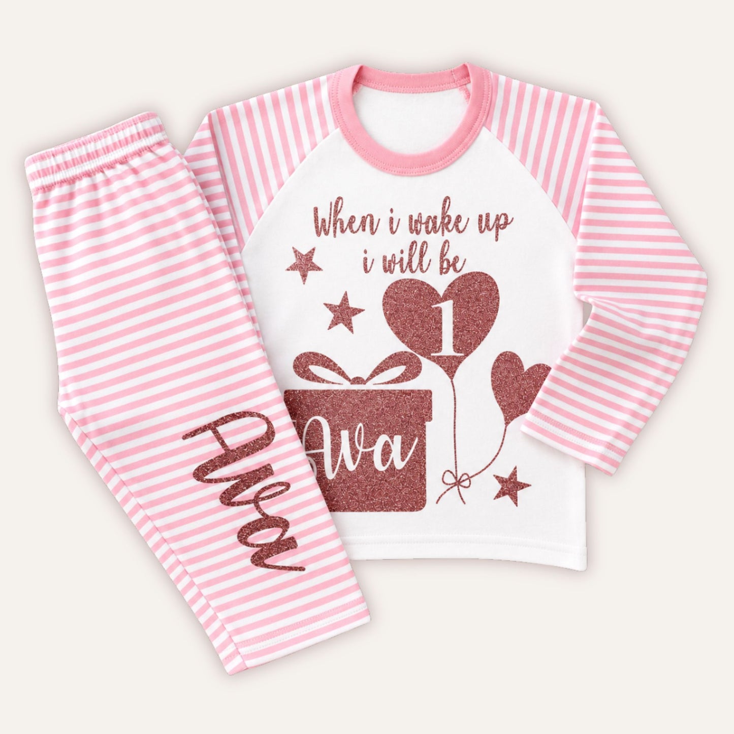 Personalised girls 1st birthday pink striped pyjamas featuring glitter birthday design, heart balloon number 1, custom name and matching striped trousers.