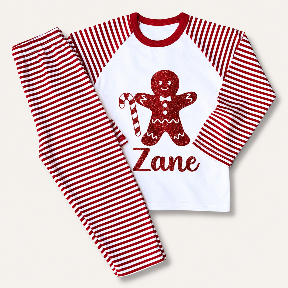 Personalised red and white striped Christmas pyjamas with gingerbread man and candy cane design by Grace & Grayson