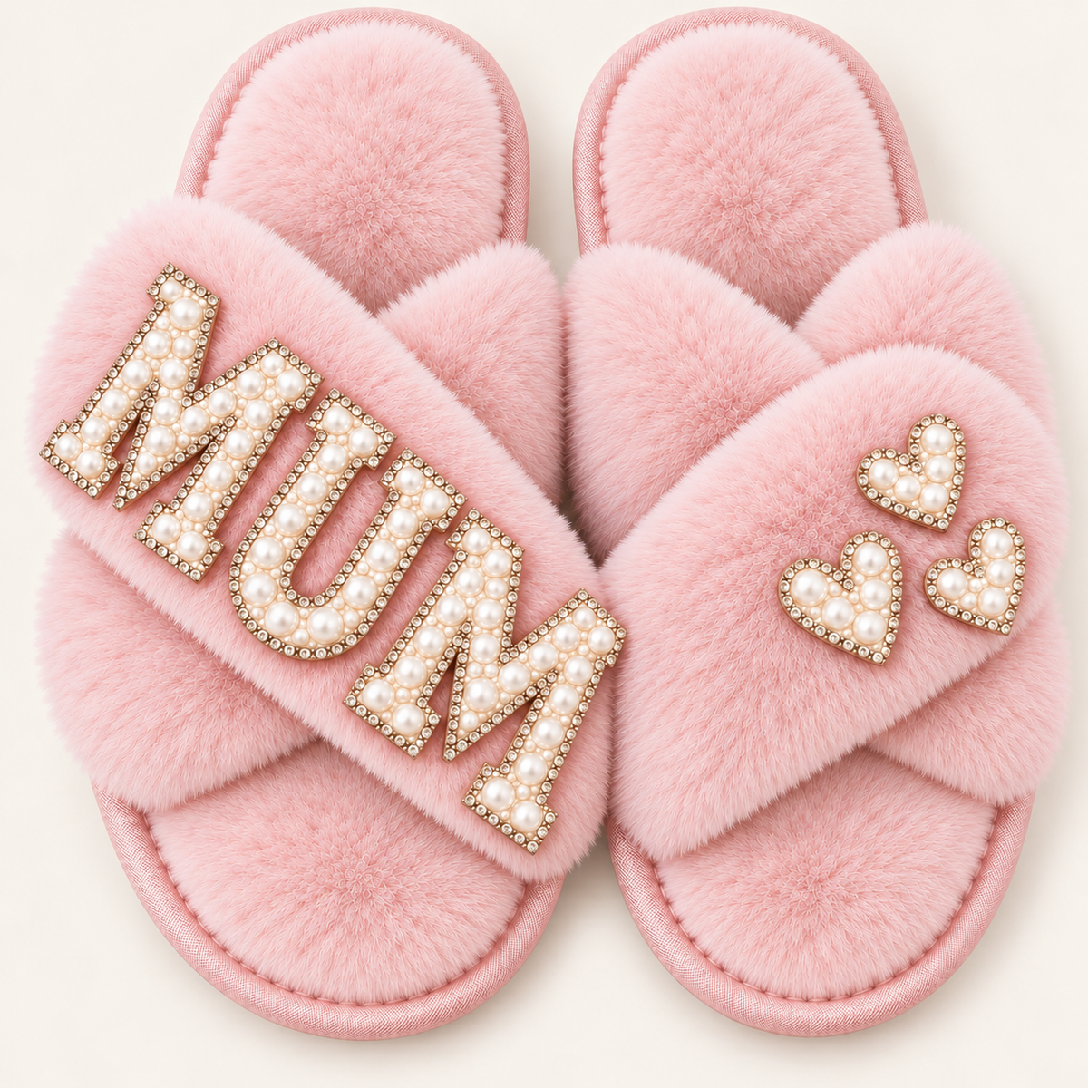 Pink faux fur crossover slippers with pearl “MUM” lettering and three pearl hearts, shown on a light background, Grace & Grayson.