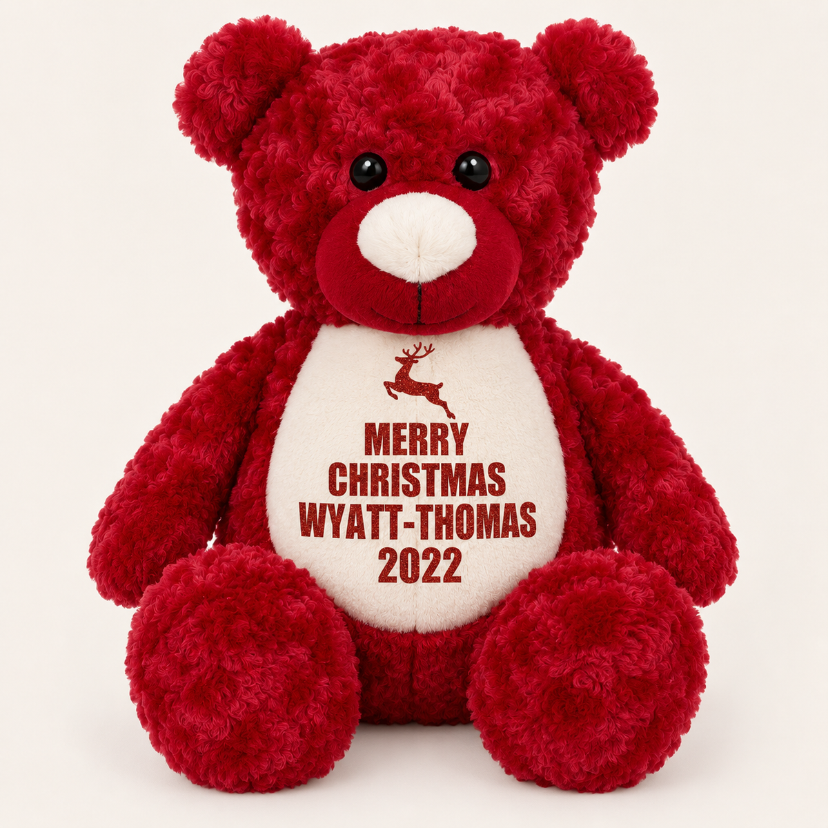 Red personalised Christmas teddy bear with a reindeer design and Merry Christmas message on the tummy, displayed on a light background, Grace & Grayson