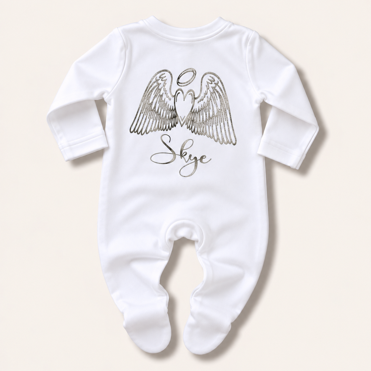 White footed baby grow with silver angel wings, halo and personalised name print, laid flat on a pale background, Grace & Grayson