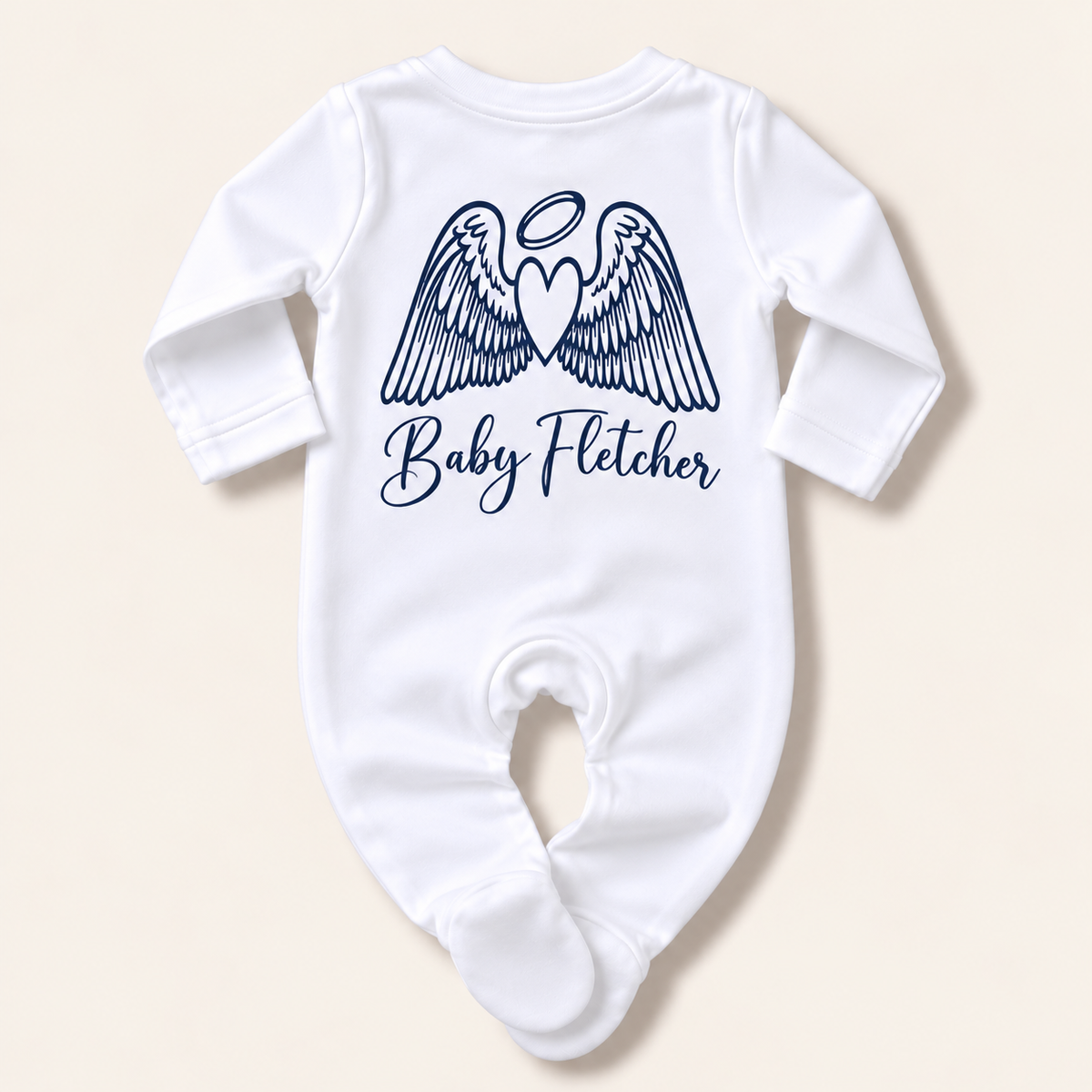 White footed baby grow featuring the Angel Wings motif and custom name in navy blue, photographed on a light background, Grace & Grayson