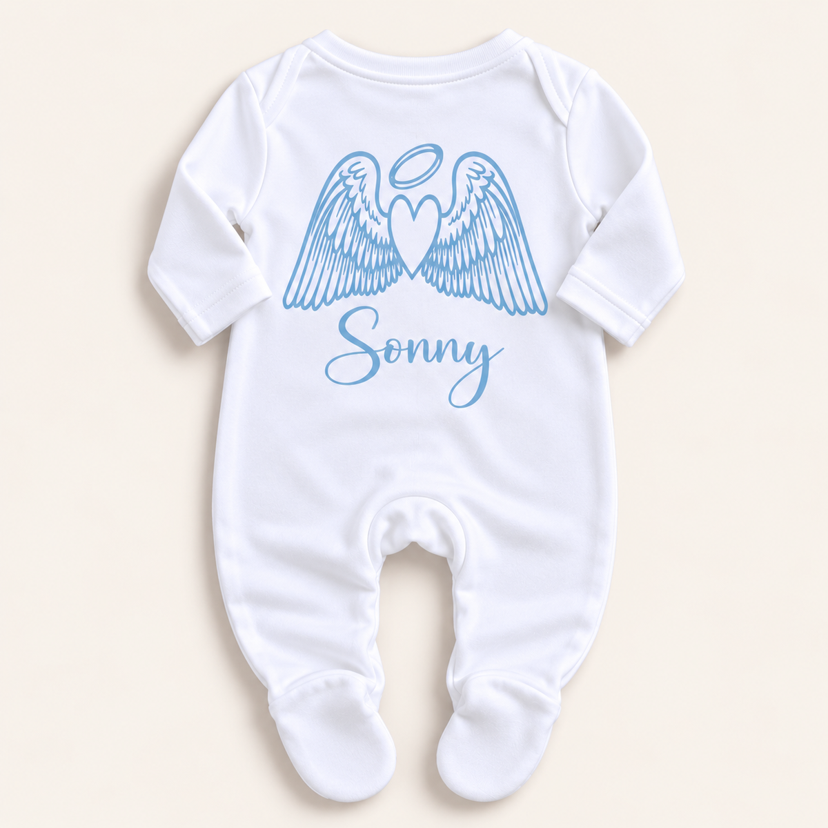 White footed baby grow with blue angel wings, halo and personalised name print, laid flat on a pale background, Grace & Grayson