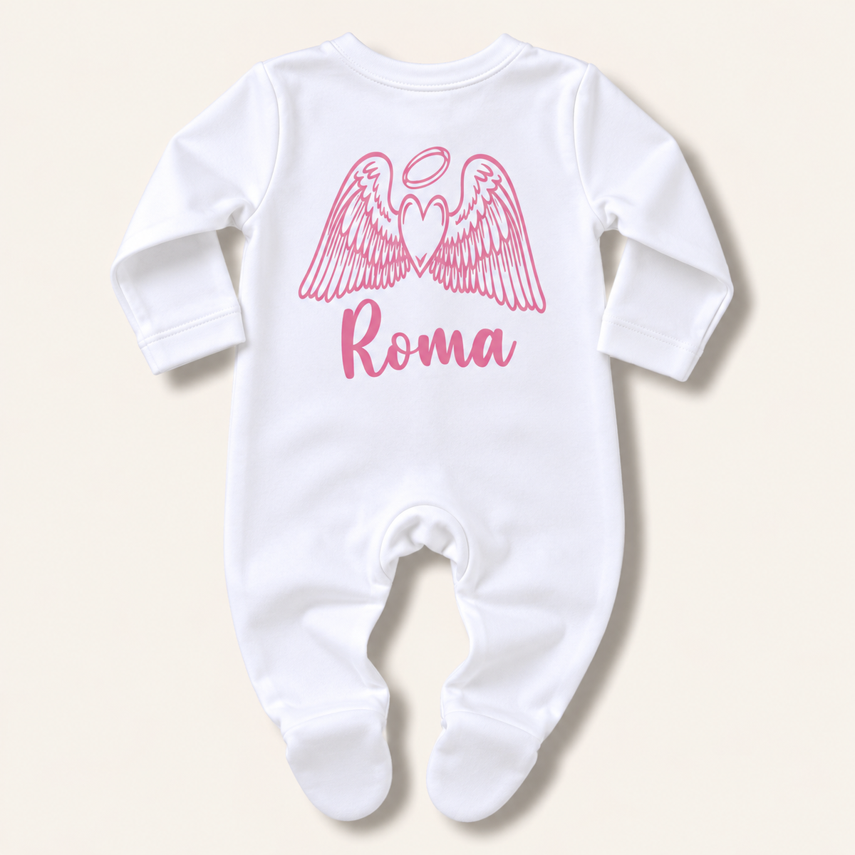 White footed baby grow with pink angel wings, halo and personalised name print, laid flat on a pale background, Grace & Grayson