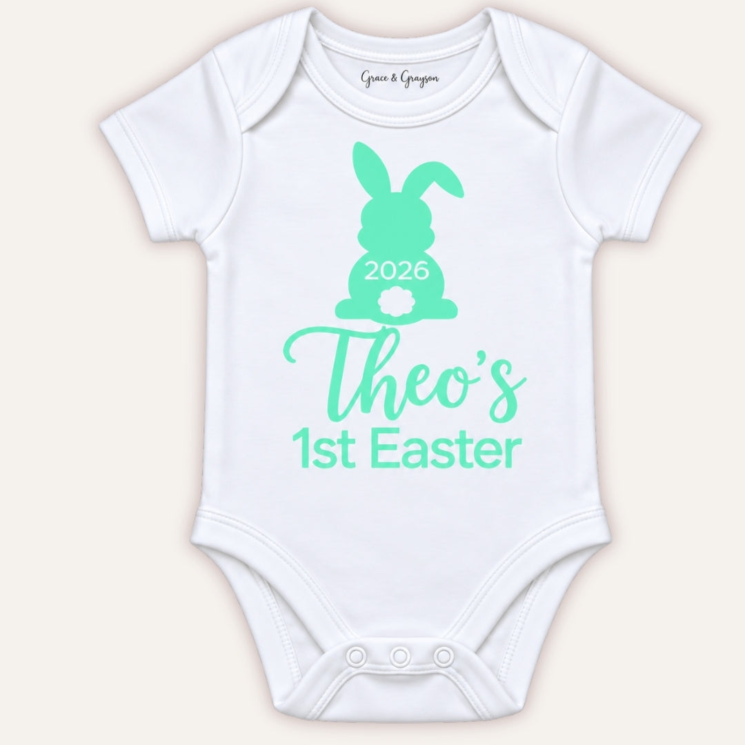White personalised 1st Easter baby vest with a mint-green bunny design and 2026 detail, Grace & Grayson