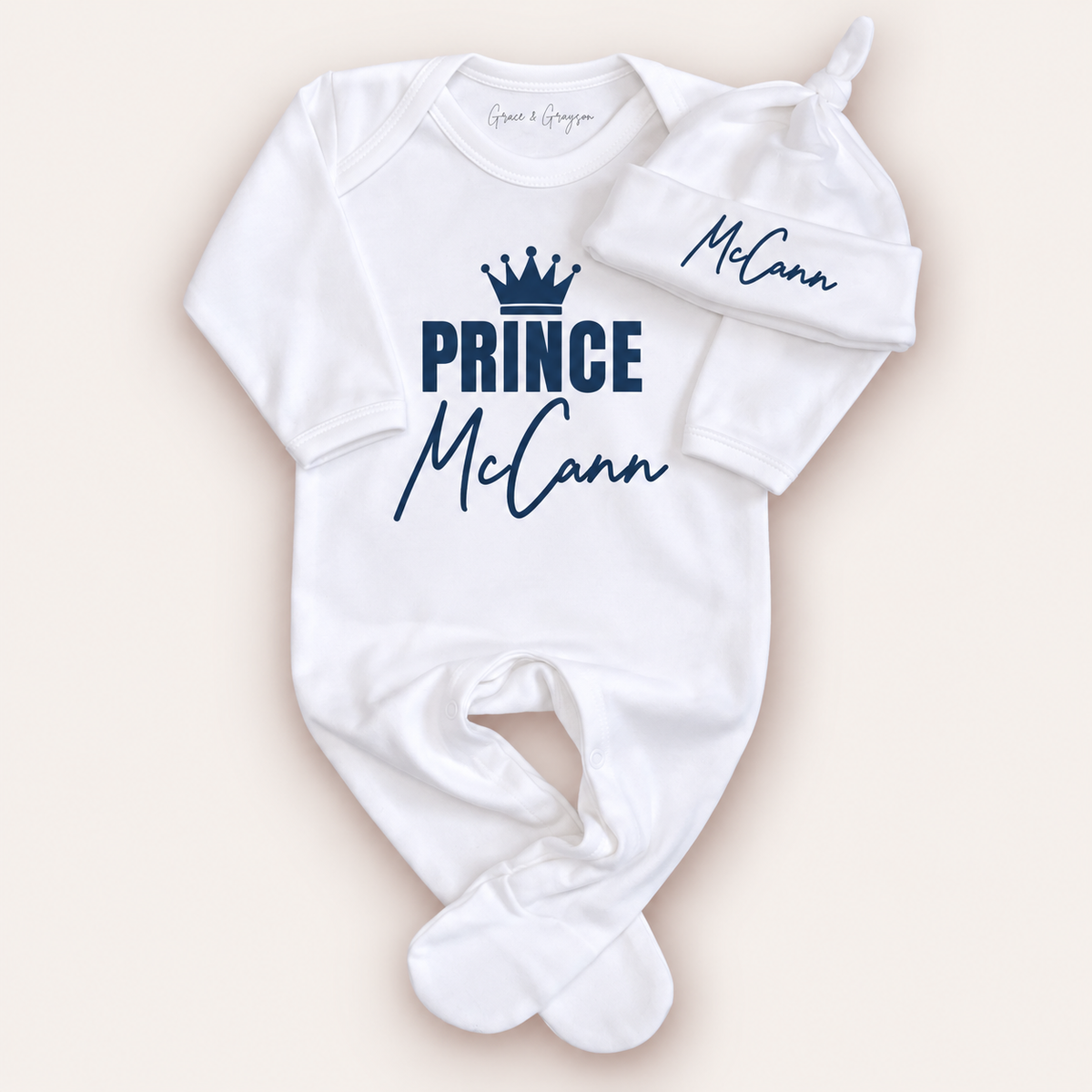 White personalised Prince baby grow and matching hat with navy crown lettering, Grace & Grayson