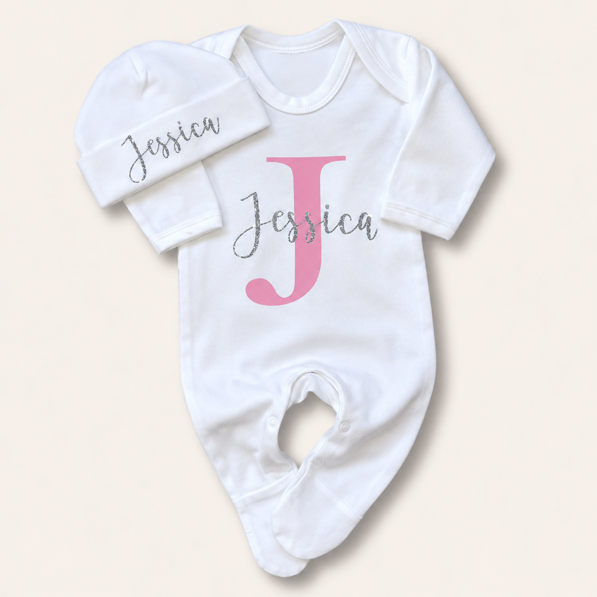 White personalised baby grow and matching hat with a pink initial design, Grace & Grayson
