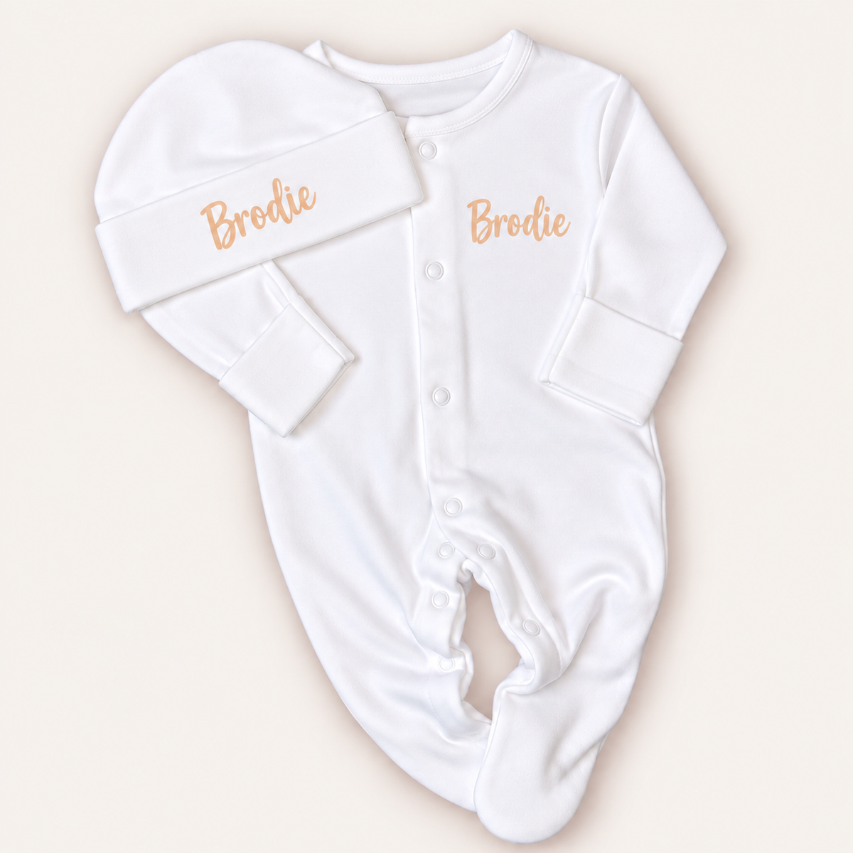 White personalised baby grow and matching hat with neutral lettering, shown on a light background, Grace & Grayson