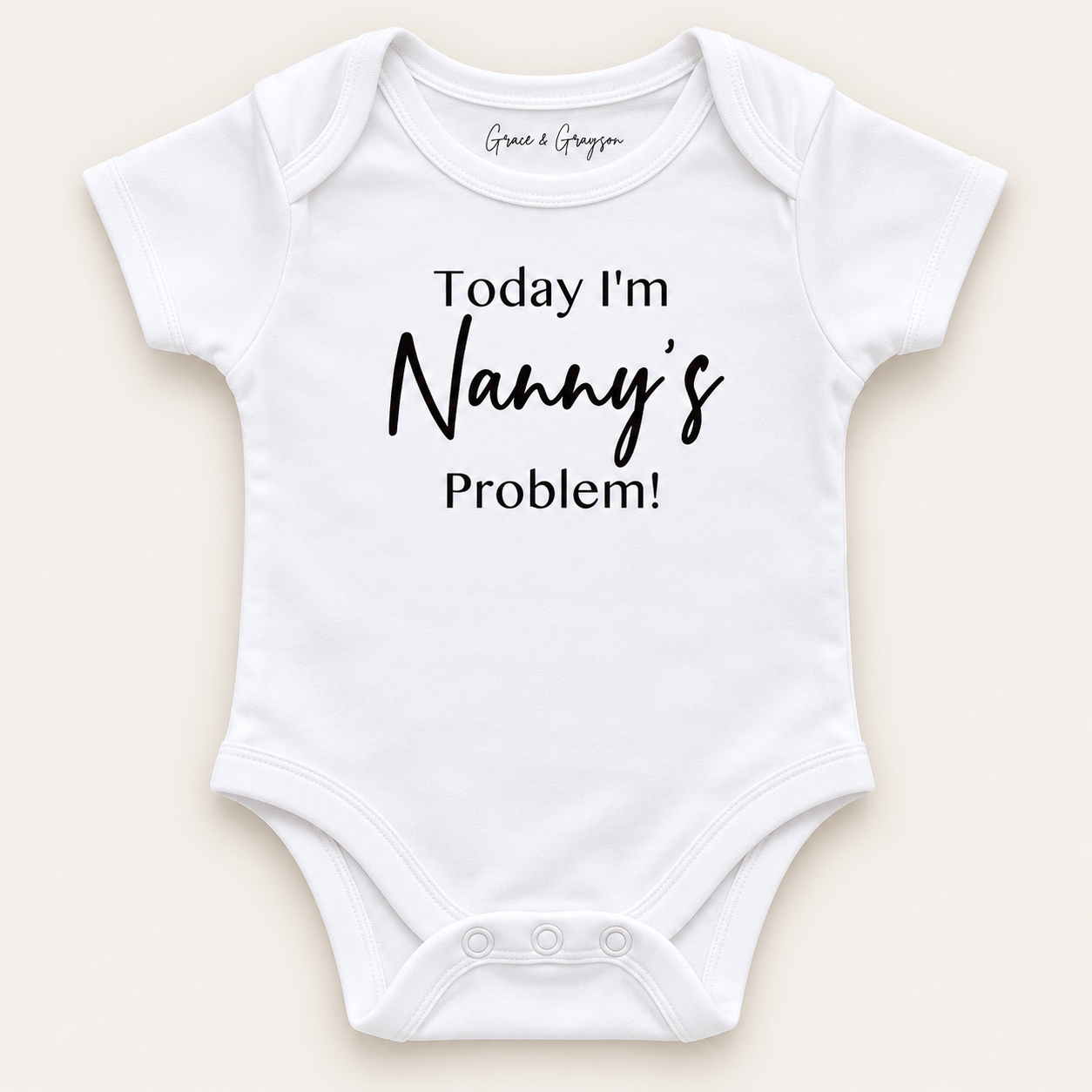 White personalised baby vest with black lettering reading “Today I’m Nanny’s Problem!”, displayed on a light background, Grace & Grayson.