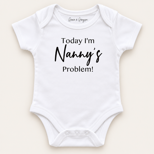 White personalised baby vest with black lettering reading “Today I’m Nanny’s Problem!”, displayed on a light background, Grace & Grayson.