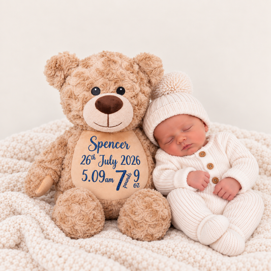 Newborn in a white knitted outfit and pom-pom hat beside a fluffy brown personalised teddy with a cream muzzle and tummy showing birth details, Grace & Grayson