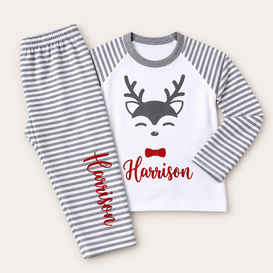 Personalised grey stripe Christmas reindeer pyjamas laid flat with a festive reindeer design and red bow, Grace & Grayson
