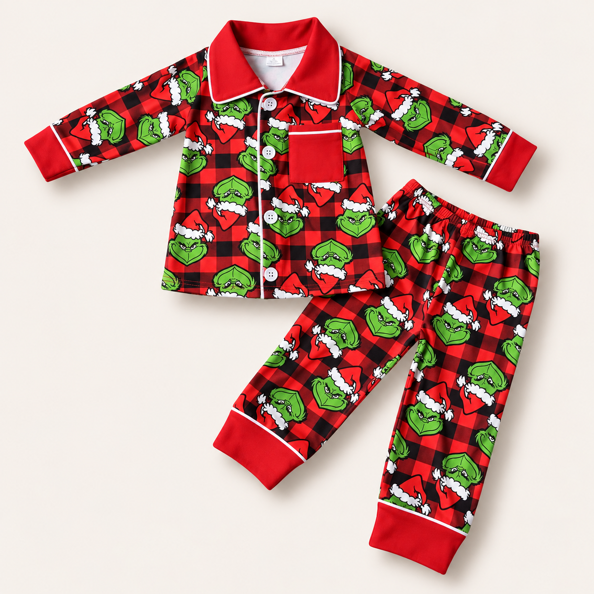 Personalised boys’ red and black Grinch Christmas pyjamas with button front and Grinch print by Grace & Grayson