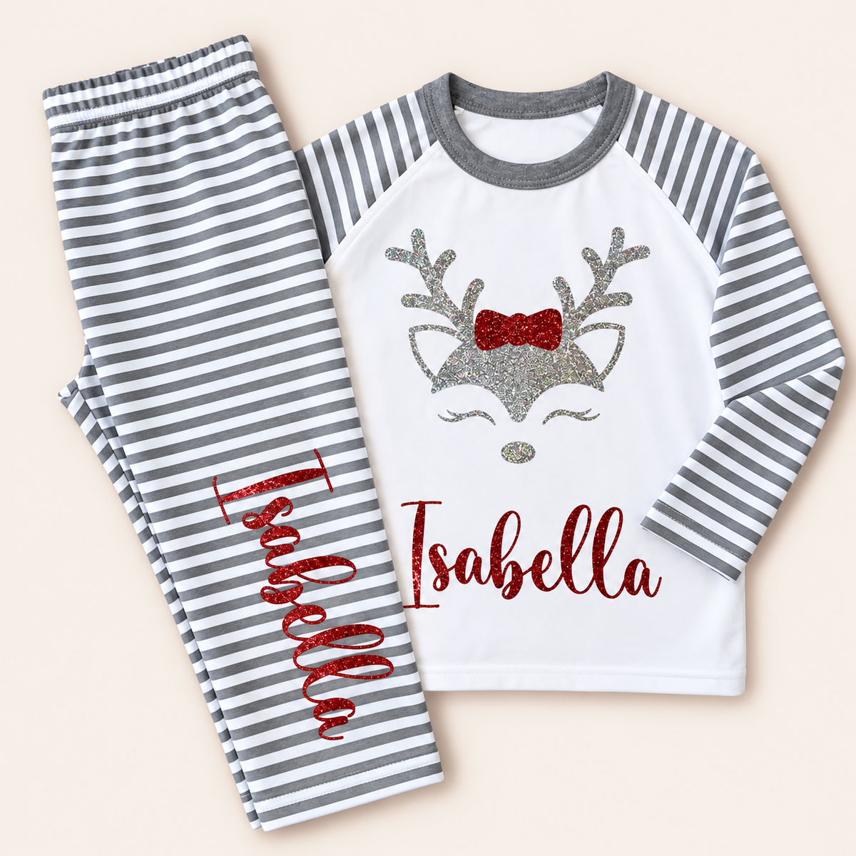 Personalised grey stripe Christmas reindeer pyjamas laid flat with a festive reindeer design and glitter details, Grace & Grayson