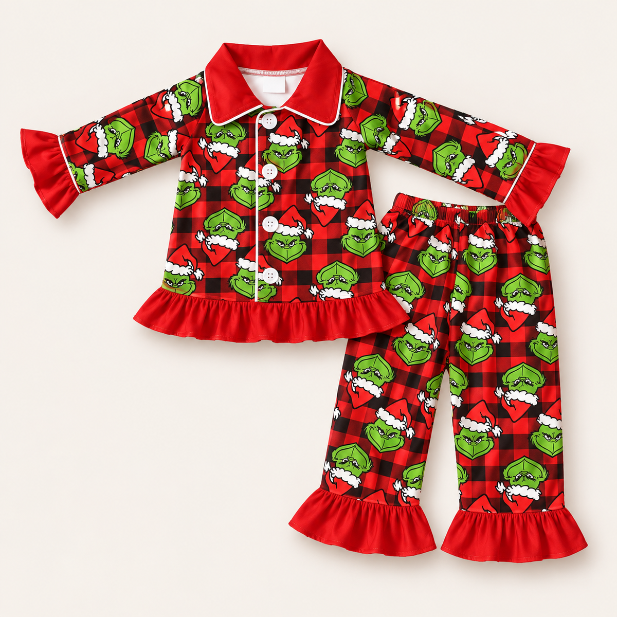 Personalised girls’ red, black & green Grinch Christmas frill pyjamas with ruffle hem and sleeves by Grace & Grayson