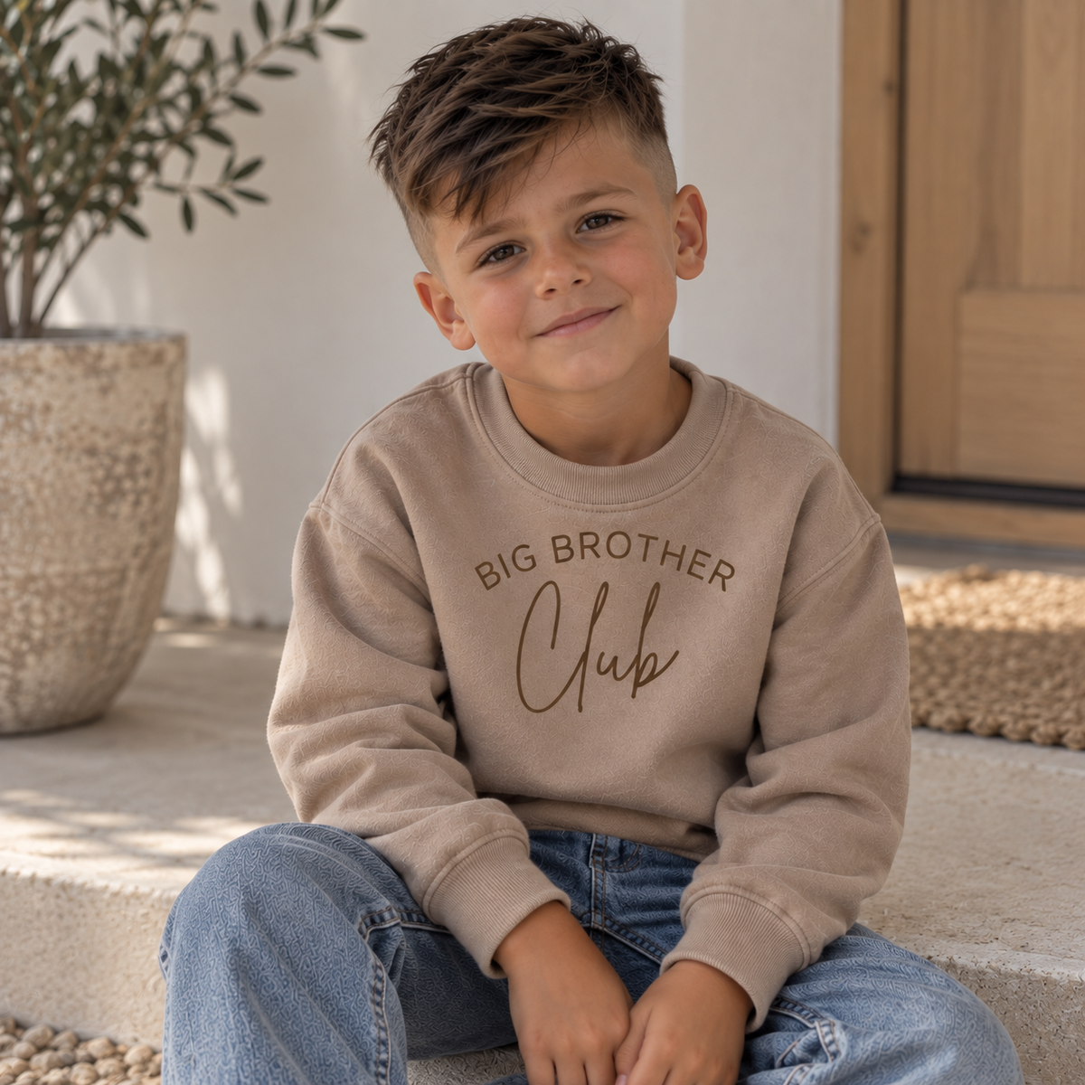 Child wearing a warm taupe personalised Big Brother Club sweatshirt with Big Brother Club lettering, Grace & Grayson