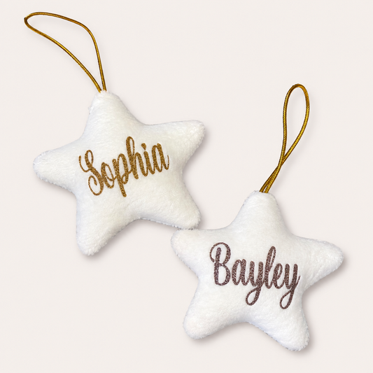 Two white personalised Christmas star tree decorations with gold and silver glitter lettering, displayed together, Grace & Grayson