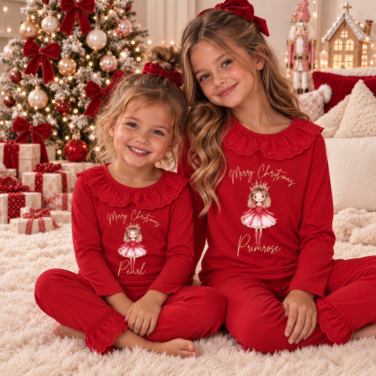 Two girls wearing matching red personalised Sugar Plum Christmas frill pyjamas in a festive Christmas setting, Grace & Grayson