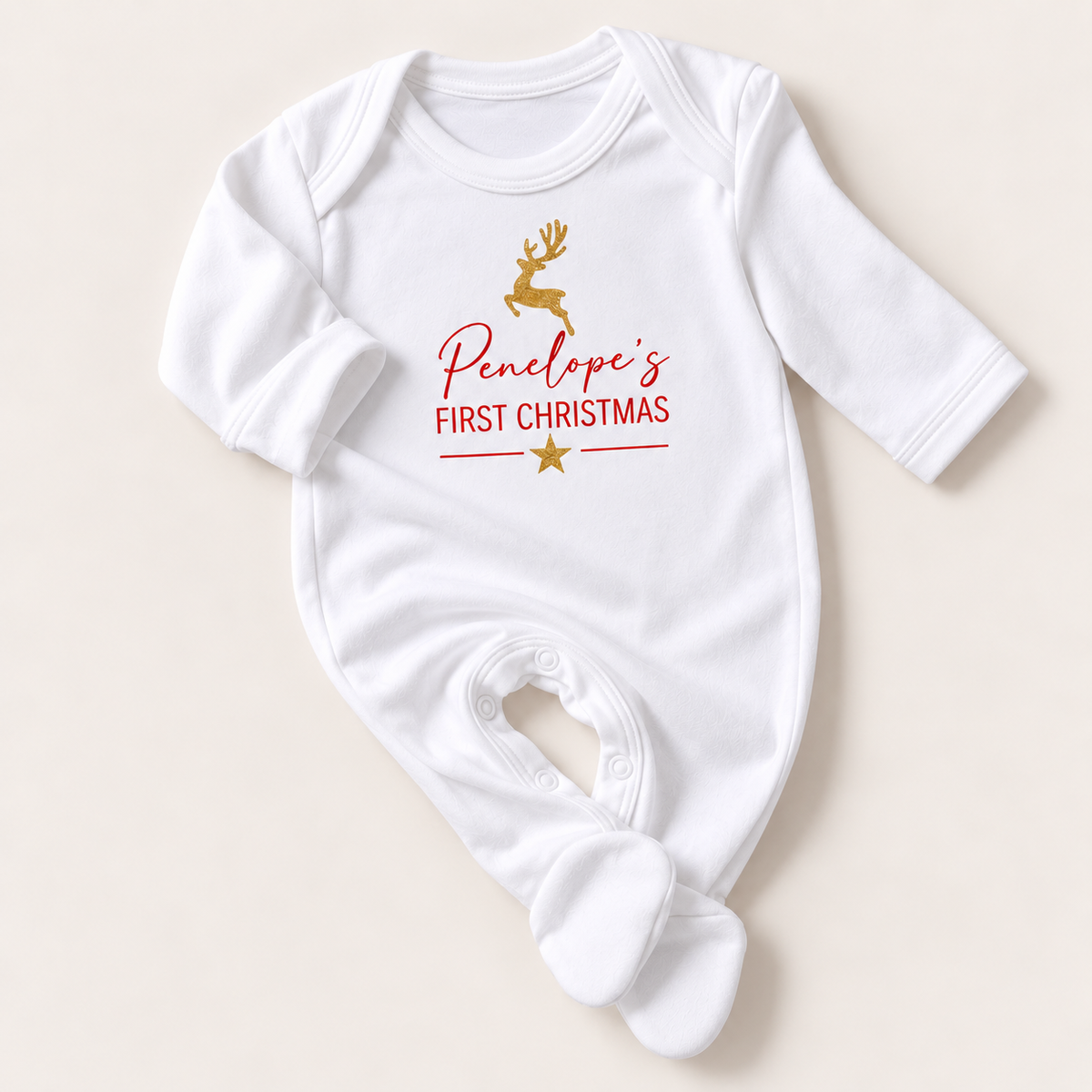 White baby grow with a gold reindeer, red First Christmas lettering and gold star, Grace & Grayson.