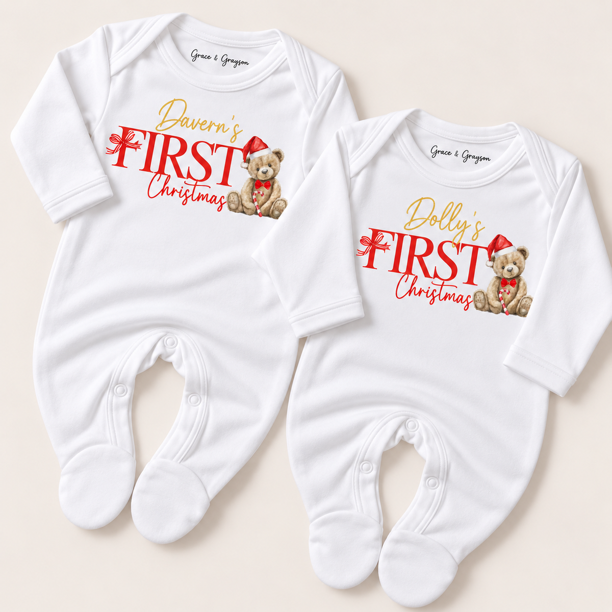 Pair of white footed baby grows with red and gold First Christmas designs and teddy bears in Santa hats, Grace & Grayson.